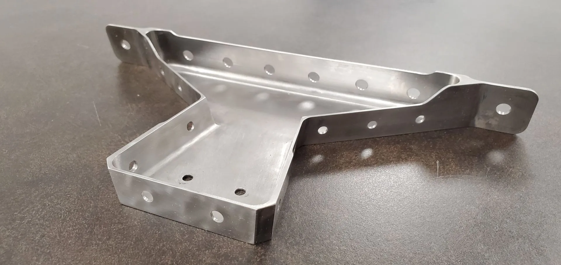 Aerospace structural component on a rotary fixture in a five-axis machining centre.