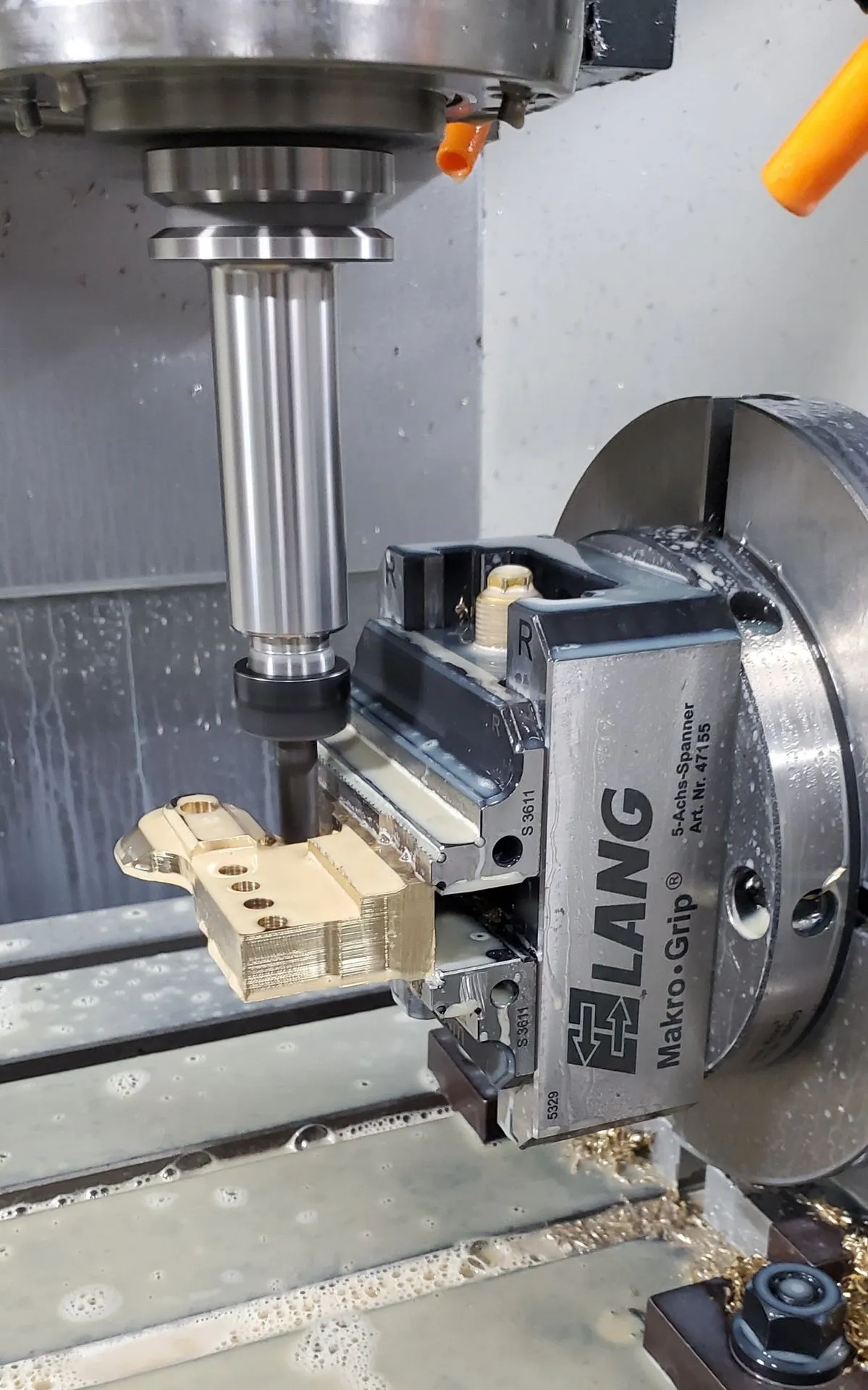 Five-axis machining centre cutting an aluminum component.
